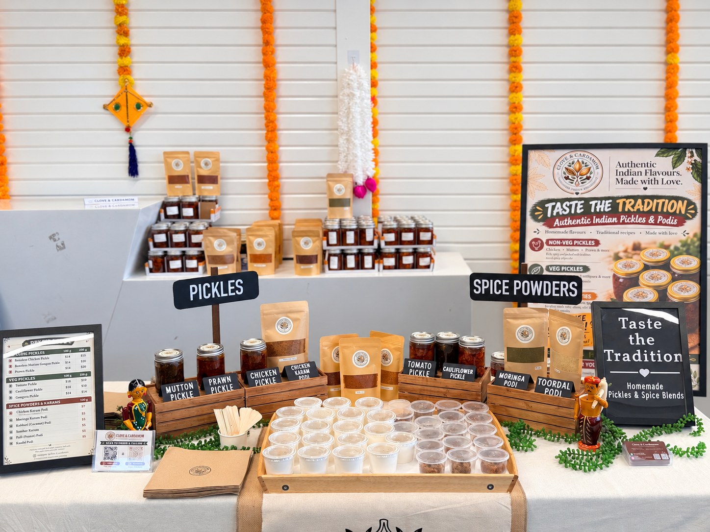 Clove & Cardamom market display with packed podi pouches and pickle jars